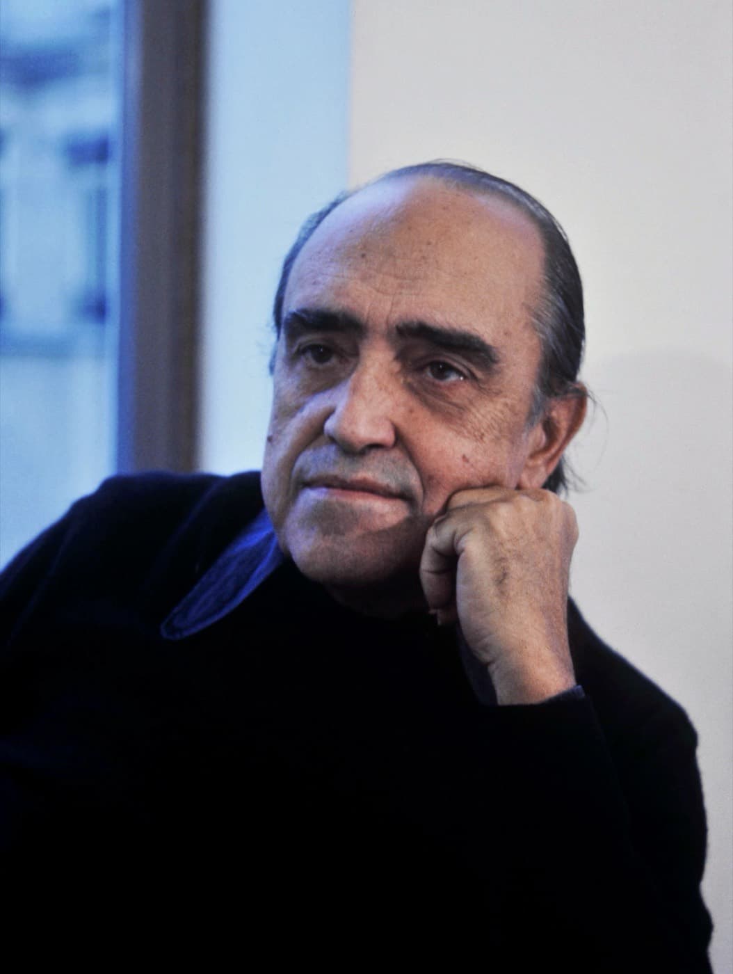 Oscar Niemeyer in 1977, resting his chin on his hand.